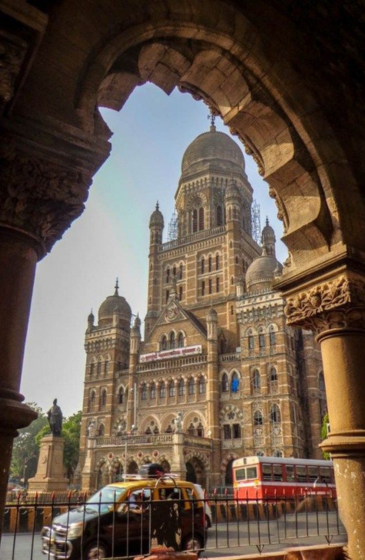 Confident male actor posing outdoors in a stylish outfit, representing modeling and travel lifestyle.
